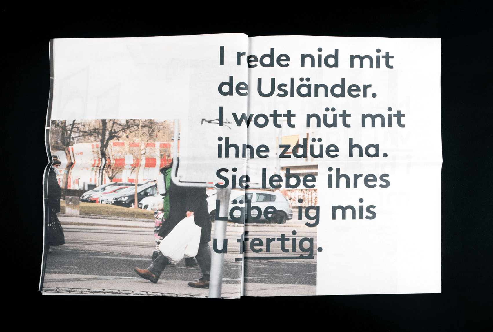 Page du journal avec image d'un homme qui passe derrière un panneau et le texte; I rede nid mit de Usländer. I wott nüt mit ihne zdüe ha. Sie lebe ihres Läbe, ig mis u fertig.